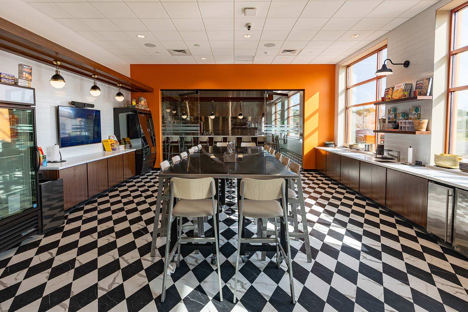 Facility Kitchen shot of a table with ovens in the background.